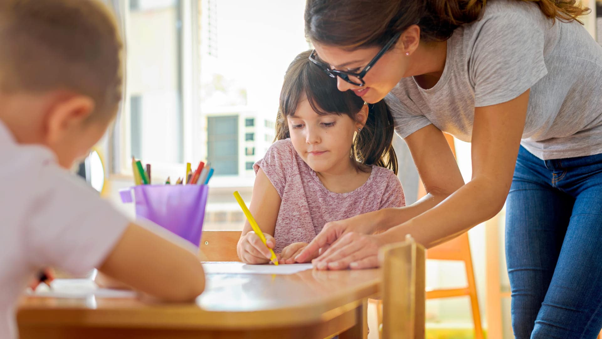 Profesor ayudando a un alumno gracias al máster de Innovación Educativa y Métodos de Enseñanza. Ayúdales a Desarrollar su Potencial con el Máster en Educación Personalizada