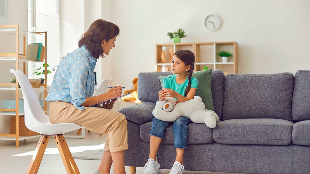 Psicóloga infantil en terapia psicológica con una niña